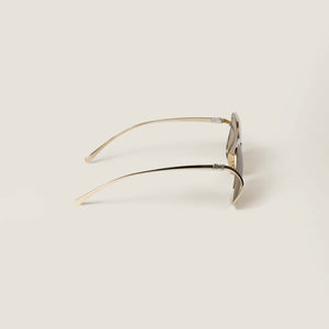 משקפי שמש מיו מיו, מסגרת מתכת זהב, הגנה UVA/UVB, רפידות אף מתכווננות.