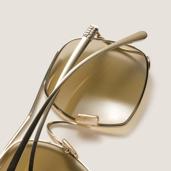 משקפי שמש מיו מיו עם מסגרת מתכת זהב, הגנה מלאה מפני UVA/UVB, רפידות אף מתכווננות.