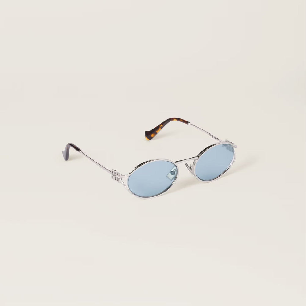 משקפי שמש מיו מיו אובליות מתכת כסופות עם הגנת UVA/UVB ורפידות אף מתכווננות.