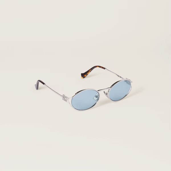 משקפי שמש מיו מיו אובליות מתכת כסופות עם הגנת UVA/UVB ורפידות אף מתכווננות.